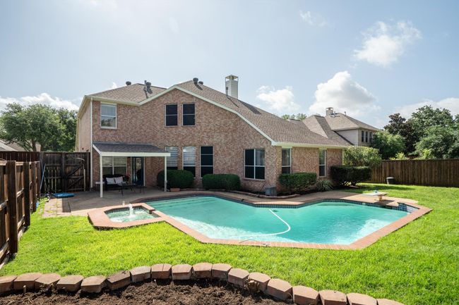 View of pool with a fenced backyard, an in-ground hot tub, a patio, and a diving board | Image 37