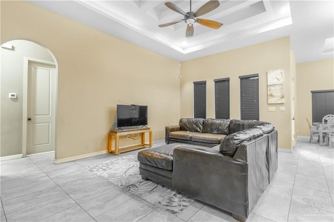 Living room featuring ceiling fan and a tray ceiling | Image 11