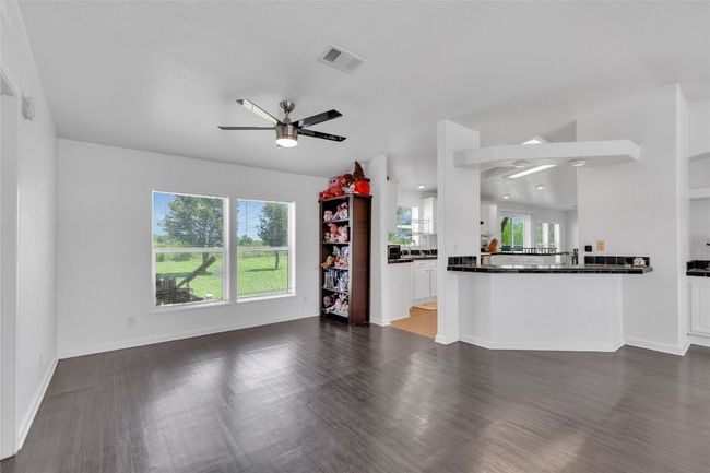 Unfurnished living room featuring a ceiling fan and wood finished floors | Image 7