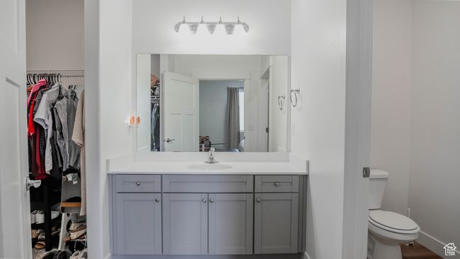 Full bath featuring a walk in closet, toilet, vanity, and baseboards | Image 26