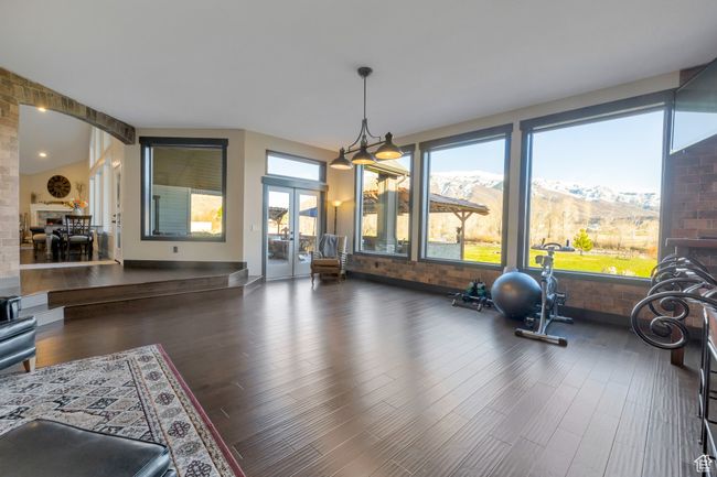 Exercise room featuring arched walkways, brick wall, a mountain view, and wood finished floors | Image 17