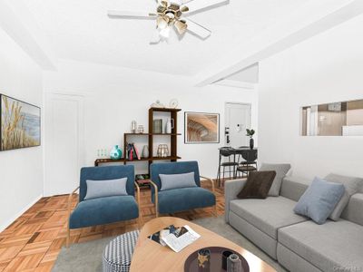 Living room with ceiling fan and light parquet flooring | Image 1