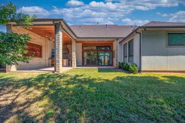 Back of property featuring roof with shingles, a patio area, and a lawn | Image 15