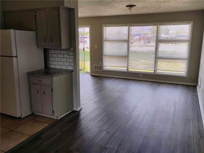 Kitchen featuring decorative backsplash, white refrigerator, hardwood / wood-style floors, and a textured ceiling | Image 2