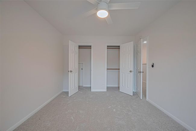 One of three secondary bedrooms upstairs, featuring closet space, all new carpet, freshly painted walls and ceiling, and a brand new ceiling fan for added comfort. | Image 29