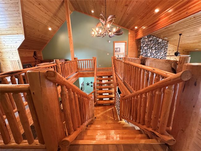 Stairs featuring an antler chandelier, wood ceiling, lofted ceiling, hardwood / wood-style floors, and recessed lighting | Image 44