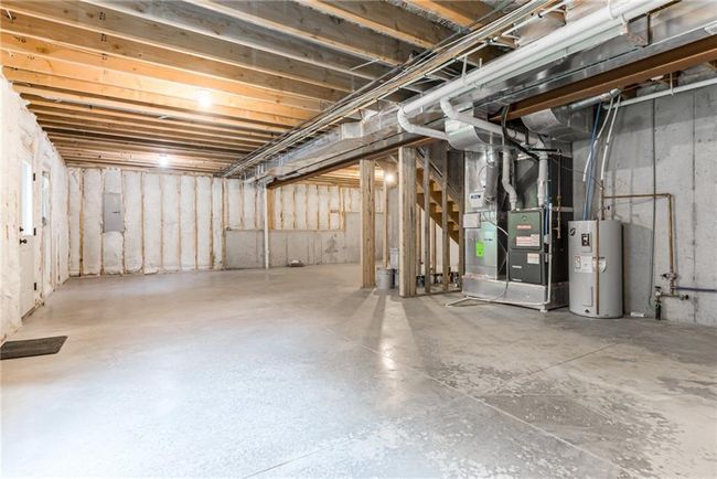 Unfinished basement with electric water heater, stairs, and heating unit | Image 43