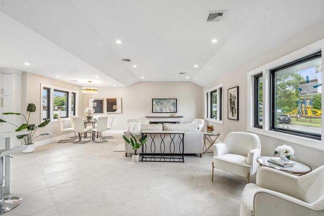 Living area featuring vaulted ceiling, recessed lighting, and a chandelier | Image 15