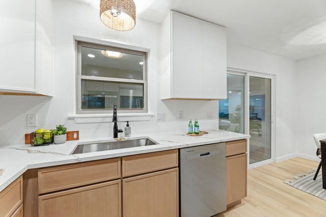 Quartz countertops with plenty of cabinet space! Window above single stainless steel sink with an upgraded faucet. | Image 9