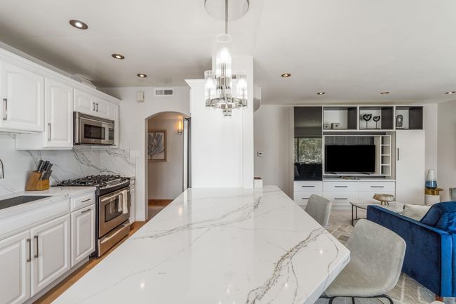 Open floor plan! The original wall dividing the living room and kitchen has been removed, providing a beautiful ocean view from the kitchen, as well as a breakfast bar seating four! | Image 12
