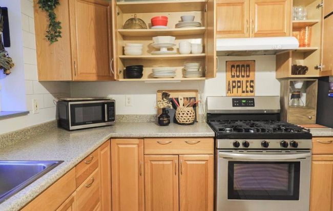 Kitchen with light brown cabinets, sink, and stainless steel appliances | Image 6