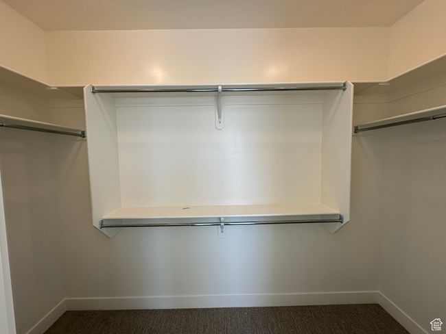 Spacious closet featuring dark colored carpet | Image 18