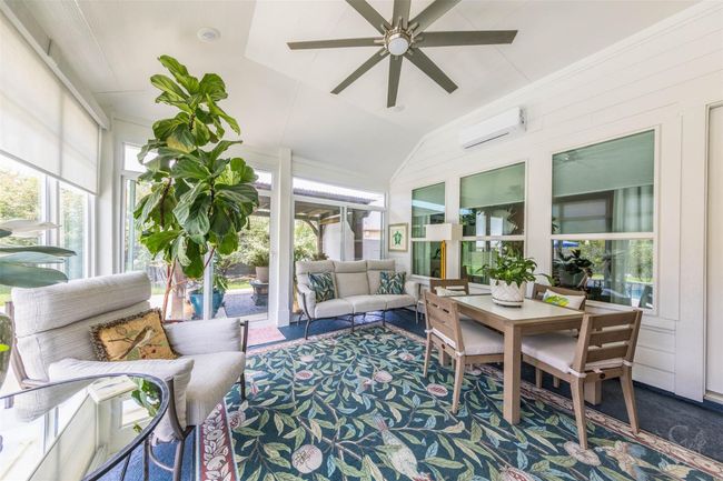 The sun room is a bright and inviting space, featuring expansive glass walls that flood the room with natural light. Custom blinds provide privacy and light control as desired. Equipped with a Friedrich AC ductless split system and remote control, this room ensures comfort year-round, making it a perfect extra space to enjoy both warm sunny and cool days. | Image 6