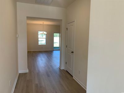 Hall with wood-type flooring and a notable chandelier | Image 3