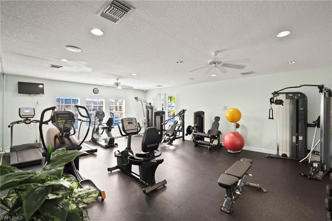 Workout area with a ceiling fan, a textured ceiling, and visible vents | Image 40