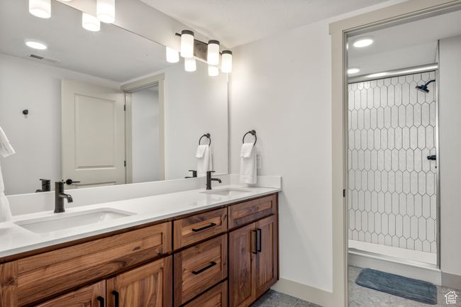 Full bathroom featuring tiled shower, double vanity, baseboards, and recessed lighting | Image 53