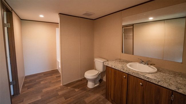 Full bathroom featuring wood finished floors, vanity, a bathtub, and recessed lighting | Image 11