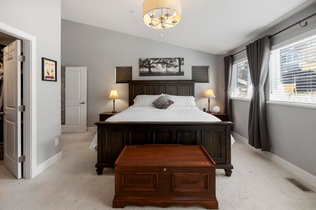 Bedroom featuring vaulted ceiling, light colored carpet, visible vents, and baseboards | Image 19