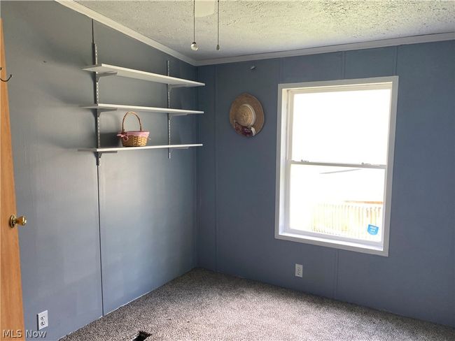 Spare room featuring a textured ceiling and carpet flooring | Image 9