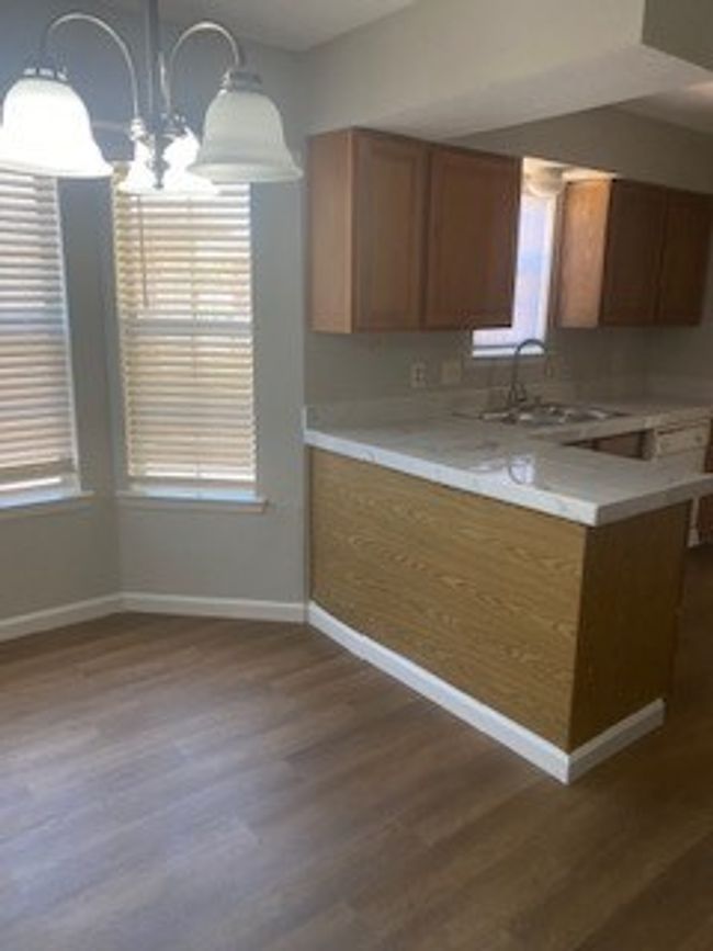 Kitchen featuring a sink, dark wood-style floors, light countertops, and baseboards | Image 5