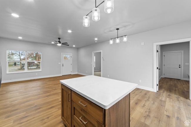 Kitchen with light wood-style floors, light countertops, recessed lighting, and a center island | Image 17