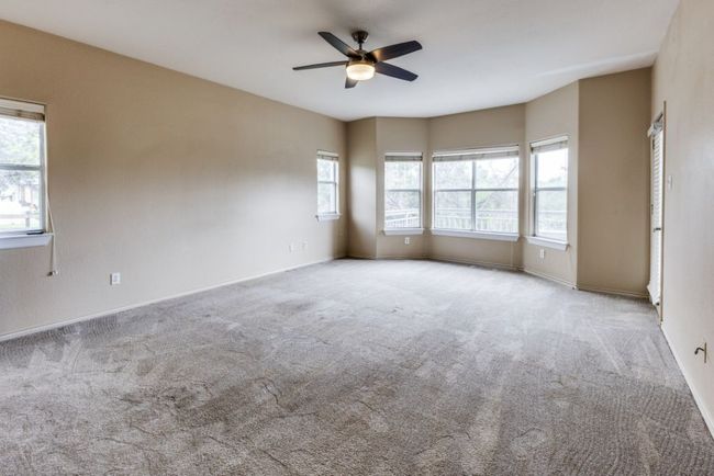 Carpeted empty room with baseboards and a ceiling fan | Image 18
