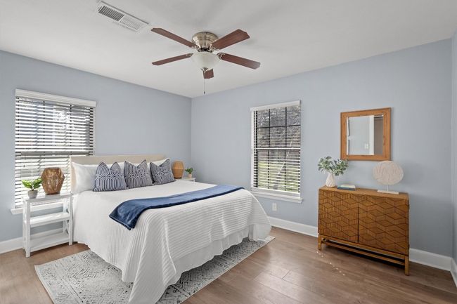 Bedroom featuring visible vents, multiple windows, baseboards, and wood finished floors | Image 18