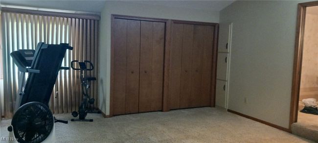 Carpeted bedroom featuring baseboards and multiple closets | Image 13
