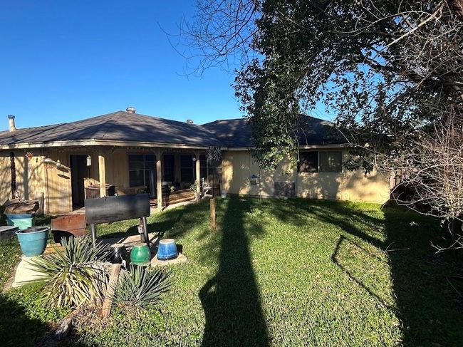 Secure and spacious backyard with a concrete slab, perfect for BBQs. | Image 5