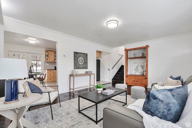 Living room featuring ornamental molding, stairs, baseboards, and wood finished floors | Image 9