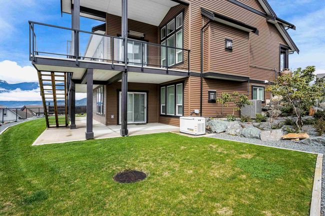 Rear view of house with a balcony, fence, a patio, and a yard | Image 37