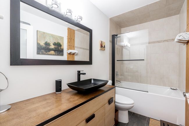 Bathroom featuring toilet, vanity, and shower / tub combination | Image 18