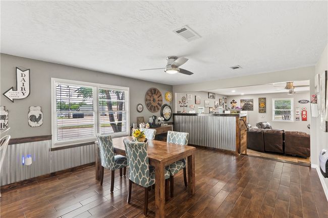 Dining area with a ceiling fan, wood finished floors, a textured ceiling, and wainscoting | Image 18