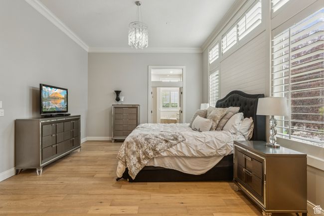 Bedroom with ornamental molding, light wood finished floors, a chandelier, and ensuite bath | Image 27