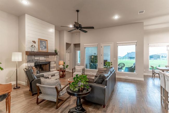 Living room featuring hardwood / wood-style flooring, a fireplace, and ceiling fan | Image 5