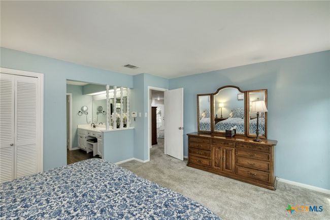 Primary Bedroom downstairs. Notice the long vanity/dressing area that is separate from the other vanity in the shower room. | Image 14