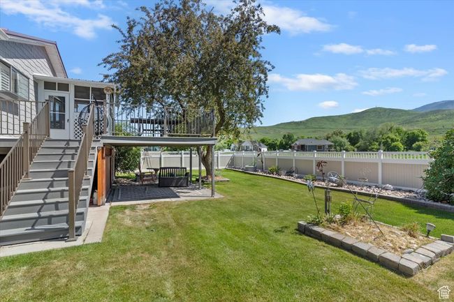 View of yard with a mountain view, a sunroom, stairs, and a patio area | Image 28