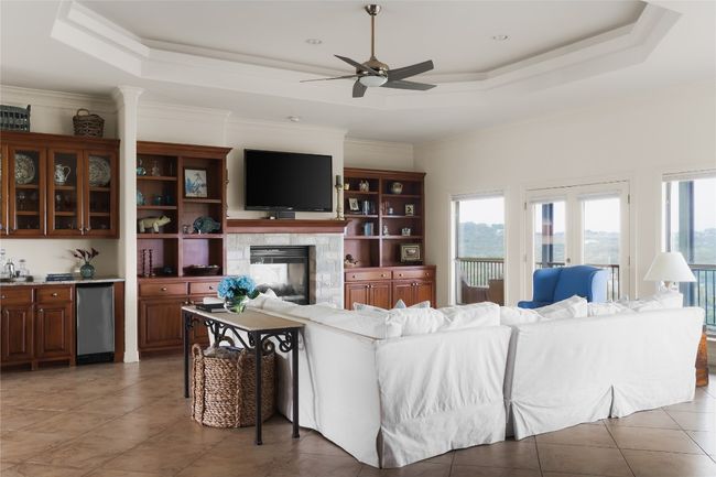 Living area featuring a tray ceiling, healthy amount of natural light, ceiling fan, and crown molding | Image 22