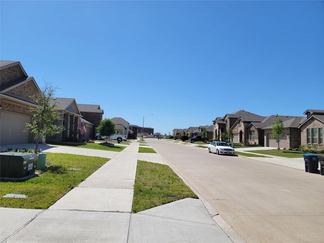 View of concrete street featuring a residential view, sidewalks, and street lighting | Image 29