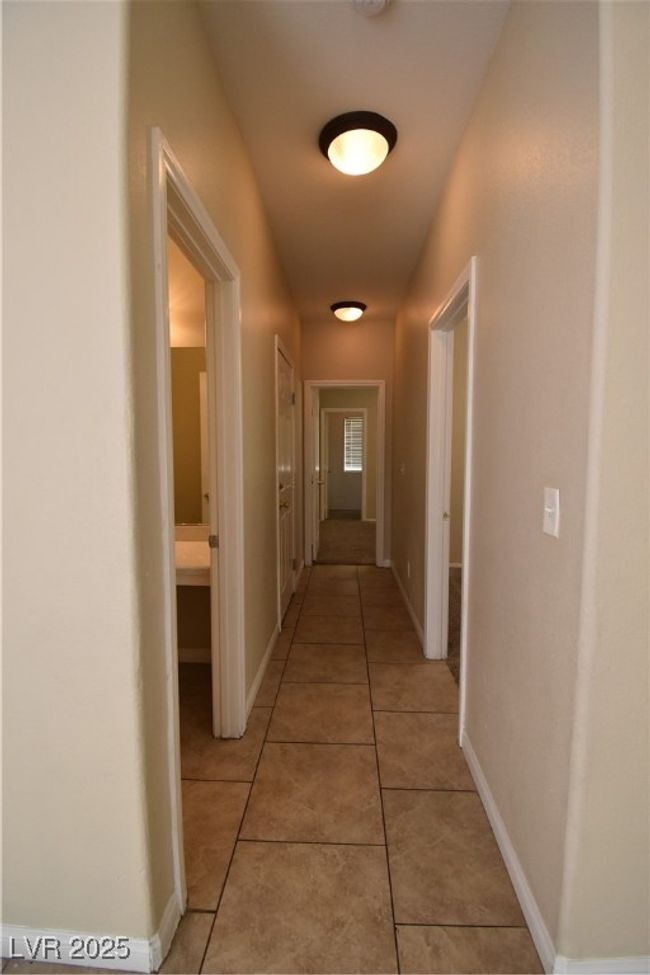 Hall featuring light tile patterned flooring and baseboards | Image 15