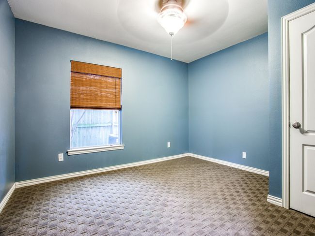 Spare room featuring a ceiling fan, baseboards, and dark colored carpet | Image 14