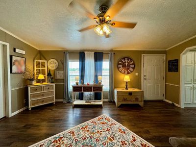 Living area featuring dark wood-type flooring, ceiling fan, crown molding, and a textured ceiling | Image 2