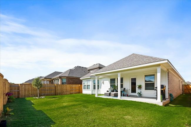 Back of property featuring a patio, a fenced backyard, a shingled roof, a lawn, and brick siding | Image 30