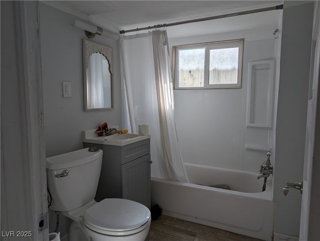 Bathroom featuring toilet, shower / bath combination with curtain, and vanity | Image 19