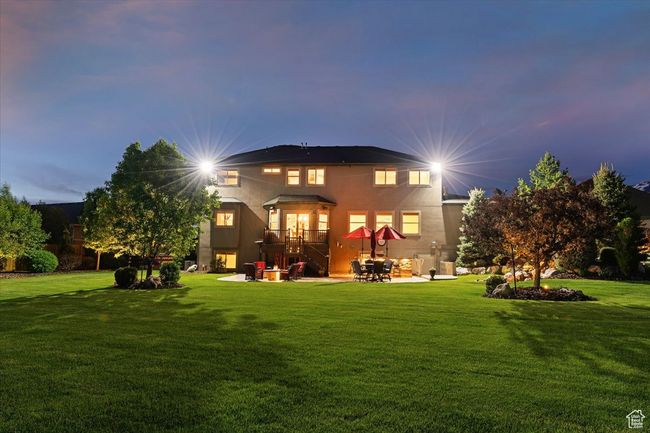 Rear view of house with a patio area, a yard, and stucco siding | Image 67