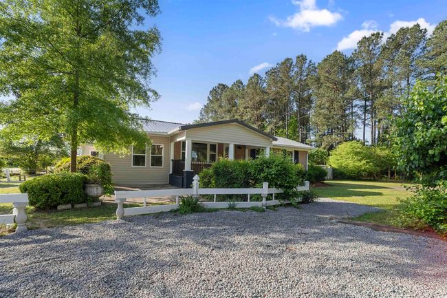 View of front of home with a metal roof and a porch | Image 9