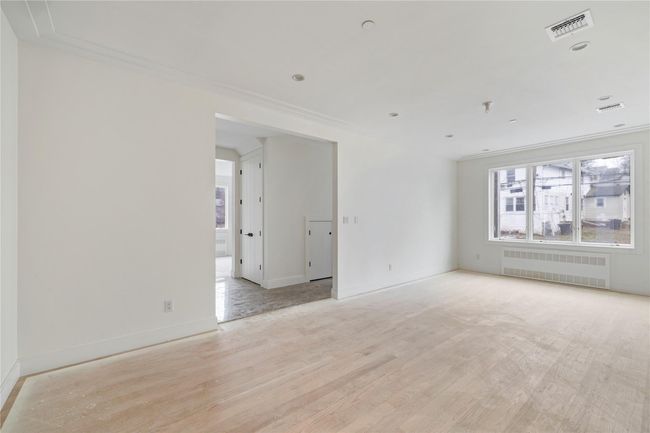 Unfurnished room with light wood-type flooring, baseboards, visible vents, and radiator | Image 12