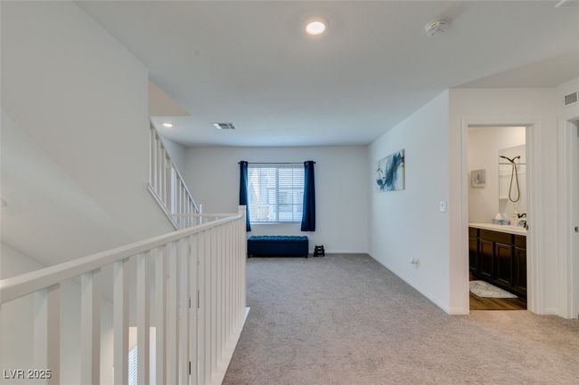 Corridor with light colored carpet, visible vents, and baseboards | Image 21
