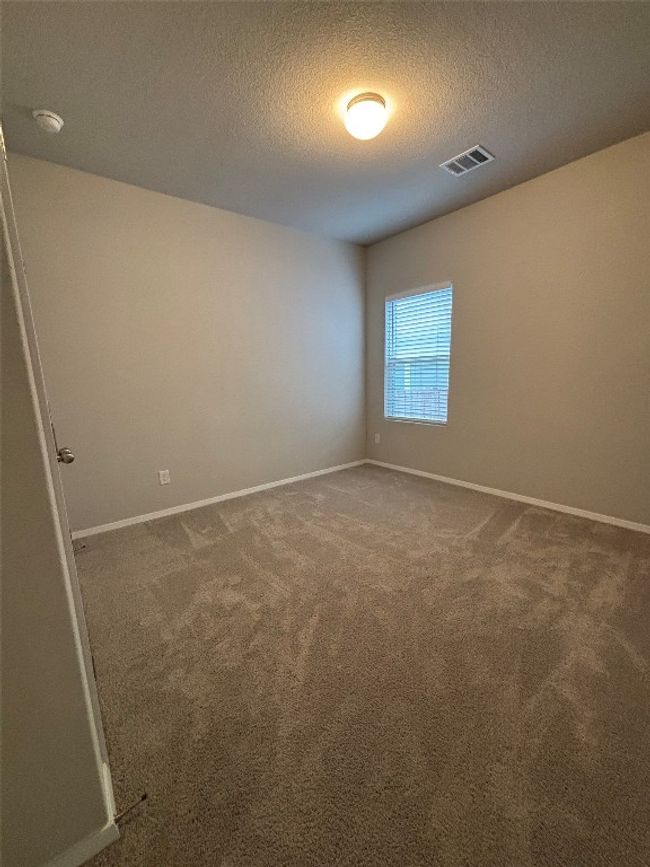 Carpeted spare room with baseboards, a textured ceiling, and a smoke detector | Image 12