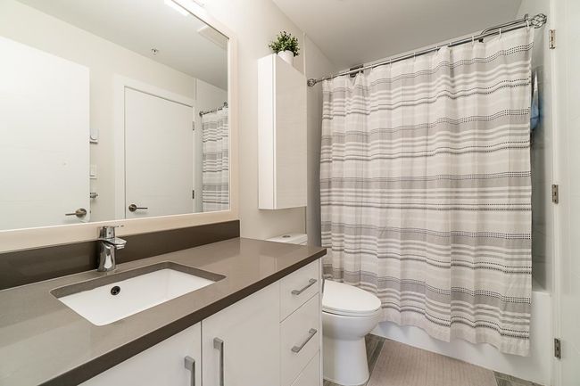 Full bath featuring shower / tub combo, vanity, tile patterned flooring, and toilet | Image 20
